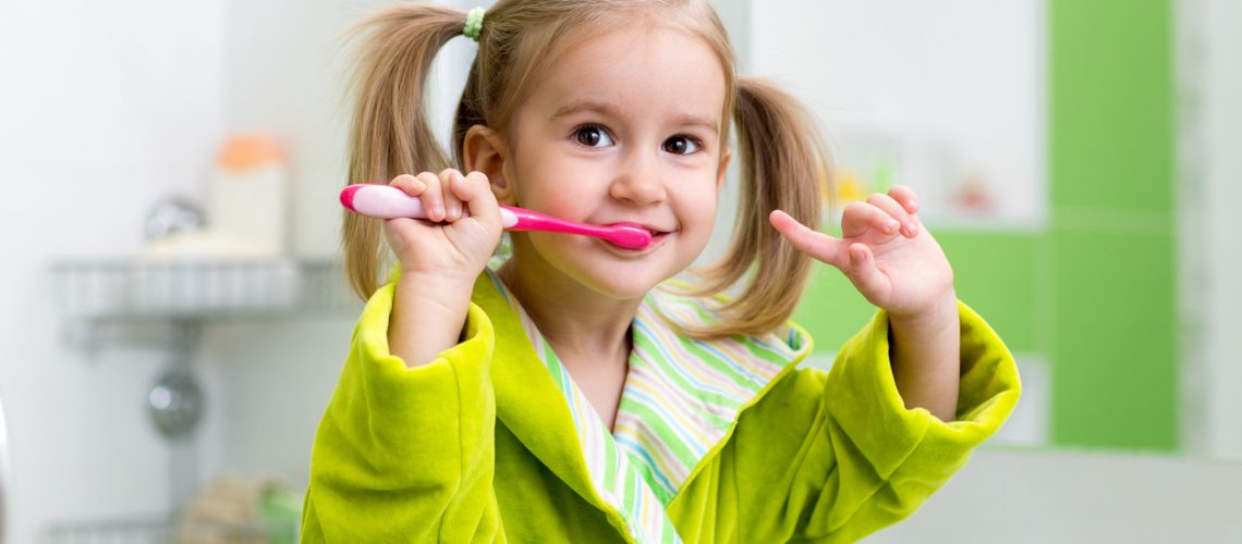Kid Girl Brushing Teeth In Bathroom